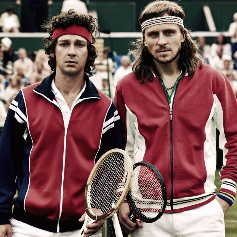 Bohaterowie filmu "Borg/McEnroe. Między odwagą a szaleństwem" na fotosie filmowym - ubrani jak tenisiści stoją na korcie.